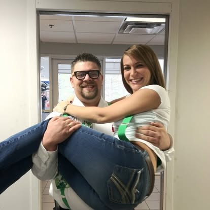 Nate laughing as he sweeps a friend off her feet.