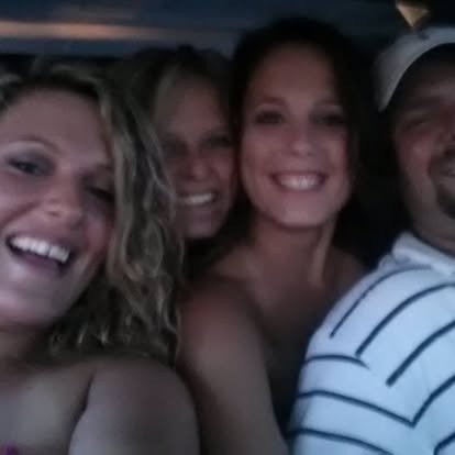Squeezed in close with friends, everyone laughing.