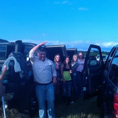 Peace sign thrown high, hanging out by the trucks with friends.